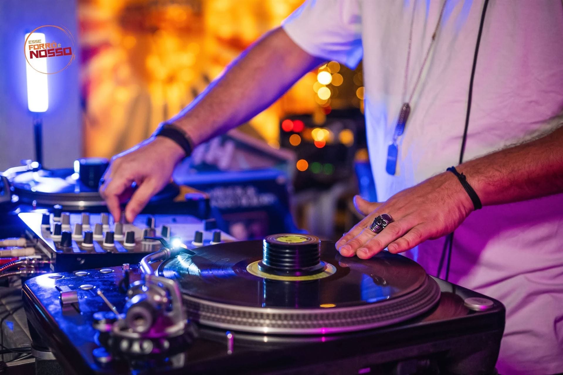 Mão de DJ tocando disco de vinil num baile de forró em Brasília